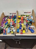Overview of two trays filled with assorted toy vehicles