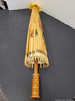 Folded parasol showing bamboo ribs and turned wood handle