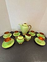 Full set arranged showing coffee pot, creamer, sugar bowl, six cups and saucers