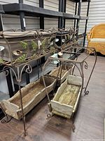 Three metal planter stands, two complete and one missing top tub