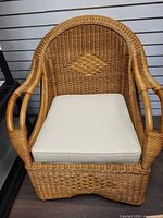 Front view of wicker armchair with cushion in place
