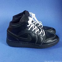 Left side profile of the black Air Jordan 1 Mid pair