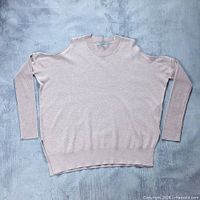 Full front view of sweater laid flat showing color, style and overall condition