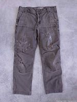 Front view of distressed greenish grey Carhartt double knee painter pants