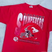 Front view of red Calgary Stampeders CFL graphic T-shirt