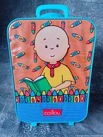 Front view showing Caillou artwork, blue trim, wheels at bottom