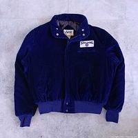 Front view of navy corduroy jacket showing overall style, snap closure, ribbed waistband and cuffs