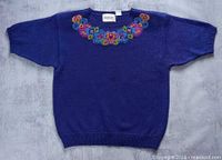 Full view of purple knit blouse with floral neckline