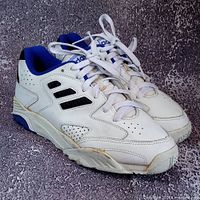 Full view of both sneakers angled right showing overall design and yellowed glue