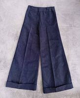 Full front view of dark wash wide-leg denim pants with cuffs
