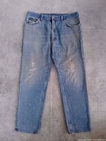 Front view showing overall light wash denim and distressed knee areas