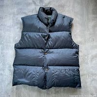 Front view of blue puffer vest showing overall style and condition