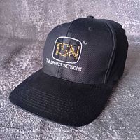 Full view of black TSN embroidered snapback cap, front angle