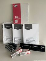 Full lot showing copy paper reams, Hilroy paper, staplers, staples boxes, three-hole punch
