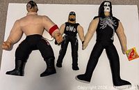 Three wrestling plush dolls side by side