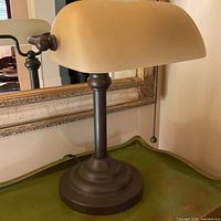 Oblique view of lamp showing bronze base, column, and cream glass shade