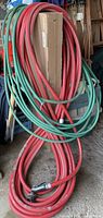 Coiled red and green garden hoses with nozzle