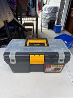 Front view of closed black/yellow toolbox showing Omega label and clear lid compartments