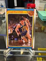 Front of John Stockton Fleer #127 card on stand