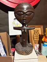 Front view of carved wooden female figure statue showing facial features and torso