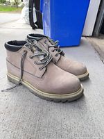 Side view of both boots showing leather uppers, laces, soles