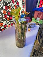 Full view of glass flower arrangement in cylinder vase on table