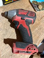 Left side view of Milwaukee red/black impact driver, battery slot empty