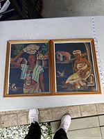 Both framed sand art pictures side by side with measuring tape indicating size