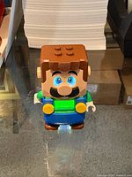 Front view of LEGO Luigi electronic figure showing LED eyes and chest screen