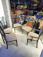 Five dining chairs arranged showing side and arm styles, spindle backs, patterned seats