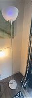 Full view of silver torchiere floor lamp with reading arm