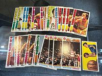 Overview of roughly 35 Topps basketball cards spread on table showing Pacers, Bullets, Warriors, Trail Blazers, All-Star subset, Phoenix card