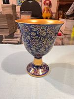 Side view showing blue cloisonné floral body, yellow banded stem and foot