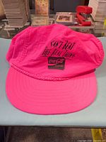 Front view of hot pink Coca-Cola cap with logo and slogan visible