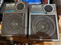 Front view of both YORX S-20 speakers showing metal grilles and attached wires