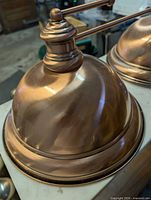 Close-up of one copper dome shade and finial