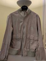 Front view of Giorgio Armani beige suede bomber jacket on hanger