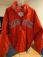 Front view of red Boston Red Sox jacket hanging