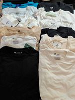 Stack of 13 assorted men's T-shirts in various colors