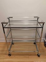Full view of chrome bar cart showing three glass shelves and casters