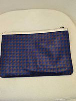 Front view of blue and brown geometric leather clutch pouch