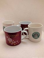 Front view of four mugs showing Starbucks and Godiva branding