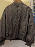 Front view of Uniqlo bomber jacket on hanger showing full style, color and condition