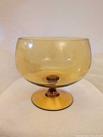 Front view of amber glass compote showing bowl shape and foot