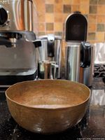 Oblique view of hammered copper bowl exterior showing shape and patina