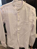 Front view of white seersucker grandad collar shirt hanging