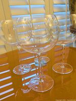 Four clear balloon wine glasses on table