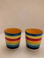 Front view of both ceramic shot cups showing exterior stripe pattern
