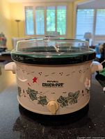 Front view showing Rival Crock-Pot logo, ivy design, control dial, glass lid