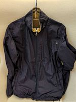 Navy shell side of reversible jacket showing front, zipper, pockets, drawcord hem